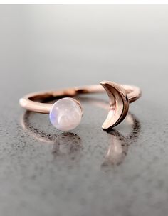 Sun and Moon Ring | Channel the power of the moon with this authentic moonstone ring. Handcrafted in 14K rose gold over sterling silver. It features an open shank sun & moon ring design and will be a wonderful addition to your ring collection. A luminous rainbow moonstone symbolizes inner growth and strength. Wear it to promote inspiration, intuition and empathy. Celestial Metal Ring Jewelry, Celestial Style Metal Ring Jewelry, Trendy Gemstone Ring Jewelry, Trendy Gemstone Ring, Celestial Style Metal Ring As Gift, Celestial Rose Gold Crystal Ring, Celestial Rose Gold Round Crystal Ring, Adjustable Moon Shaped Celestial Rings, Adjustable Moon-shaped Celestial Rings