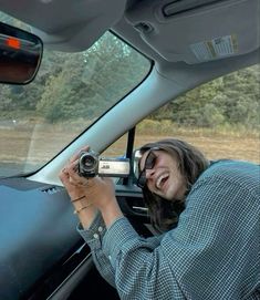 a woman taking a photo in the back seat of a car