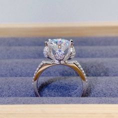 a diamond ring sitting on top of a blue carpet