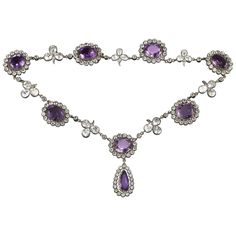 A late Victorian amethyst and rock crystal necklace, the seven oval-shaped amethysts surrounded by a cluster of round-cut rock crystal set in silver to yellow gold, each cluster separated with a rock crystal folitate trefoil, the centre cluster suspending a pear-shaped amethyst and rock crystal drop,the amethysts estimated to weigh 60 carats in total, mounted in gold and silver, circa 1880, measuring approximately 40 x 2.2cm, gross weight 62.5grams. A gorgeous and dramatic amethyst and crystal n Luxury Purple Round Necklace, Vintage Amethyst Necklace, Amethyst Oval Multi-stone Necklace, Oval Amethyst Multi-stone Necklaces, Formal Multi-stone Amethyst Necklaces, Formal Amethyst Multi-stone Necklace, Oval Amethyst Multi-stone Necklace, Formal Multi-stone Amethyst Necklace, Amethyst Jewelry Necklace