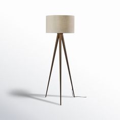 the floor lamp is made from wood and has a beige shade on it's base