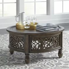 a coffee table with an ornate design on it in front of a window and rug