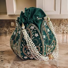 Introducing the Elegant Lotus Potli Bag by Byra, a masterpiece of traditional craftsmanship and contemporary design. This unique embroidered Indian bridal potli bag is an ideal accessory for weddings, engagements, bridesmaid gifts, and anniversary presents. Its intricate detailing and luxurious finish make it a standout piece that exudes elegance and sophistication. Description: Elegant Lotus Potli Bag - Unique Embroidered Indian Bridal Potli for Weddings, Engagements, Bridesmaid & Anniversary G Lotus Potli Bag, Potli Bag, Potli Bags, Wedding Clutch, Lighting Setups, Sequin Beading, Green Silk, Branded Handbags, Embroidered Silk