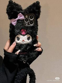 a person holding up a cell phone case with a cat face on the front and side