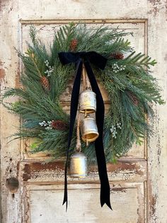 an old door with a wreath and bells on it