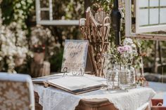 the table is set up outside for an outdoor wedding reception with flowers in vases