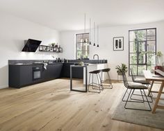 a modern kitchen with wooden floors and white walls