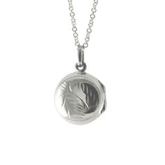 Made of .925 sterling silver. Mini round locket with etched fern accent on both sides. Silver locket opens and stores two mini photos. Comes with 16 or 18 inch chain. Measurements: 1 inch length x .62 inch diameter Material: 925 Sterling Silver Affordable Silver Round Locket Necklace, Cheap Silver Round Locket Necklace, Dainty Sterling Silver Round Locket Necklace, Silver Etched Round Locket Necklace, Antique Silver Round Locket Necklace For Keepsake, Nickel-free Metal Round Pendant Locket Necklace, Nickel-free Round Pendant Locket Necklace For Keepsakes, Ring Guide, Round Locket