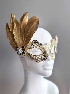 Rhinestones delicately embellish this gold women's masquerade mask, adding a touch of sparkle to your elegance. Golden feathers adorn the mask with an elegant brooch. Crafted with detail, this mask showcases the enchanting allure of gold, making you a captivating presence at any masquerade event.


Age Group/Gender - Adult/Women

Size/Type - One size fits all adults

Mask Color - Gold

Mask Material - Laser Cut Metal

Accent Material - Paint

Special Features - Feathers and a brooch Gold Adjustable Masks For Masquerade, Luxury Gold Masquerade Mask For Carnival, Luxury Traditional Gold Masquerade Mask, Gold Adjustable Masquerade Mask, Elegant Gold Theater Masks, Masquerade Event, Masquerade Mask Women, Elegant Brooch, Metal Feather