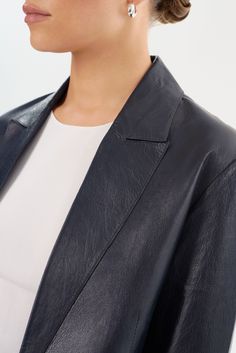 Laissez-vous séduire par l'élégance intemporelle du blazer en cuir QUIRINA, un ajout essentiel à toute garde-robe distinguée. Conçu avec un col à pointe et orné de poches à rabat classiques, ce blazer dégage sophistication et polyvalence. Sa construction non doublée garantit une sensation de légèreté, idéale pour traverser les saisons de transition avec aisance. Associez-le facilement avec un jean et un tee-shirt pour un ensemble discret mais chic, ou adoptez une allure professionnelle raffinée Elegant Outerwear With Suit Collar For Semi-formal Occasions, Luxury Formal Blazer With Double Button Closure, Luxury Blazer With Double Button And Lapel Collar, Luxury Blazer With Double Button Closure And Lapel Collar, Luxury Blazer Dress With Double Button And Notch Lapel, Sleek Structured Blazer For Semi-formal Occasions, Luxury Double-breasted Semi-formal Blazer, Luxury Tailored Leather Jacket For Semi-formal Occasions, Sleek Single Button Blazer Dress For Formal Occasions