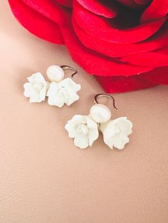 Skillfully crafted by hand, each earring showcases two delicate white clay flowers adorned with freshwater pearls. These exquisitely made flower bridal earrings are a perfect choice for your special day. 🖤 M A T E R I A L S  *  A N D  *  S I Z E  🖤 ❇️ MATERIAL & METAL: Brass- Clay Flower/Freshwater Pearl/Cubic Zirconia ❇️ METAL PLATING: Silver/Gold/Rose Gold ❇️ ESTIMATED SIZE: 3cm Length (Included Finish Post) ❇️ ESTIMATED WEIGHT: 8gram ❇️ QUANTITY: 1pair ❇️ LEAD-FREE & NICKEL FREE 🖤 A V A I L A B L E  *  F I N I S H 🖤 ❇️#1-CZ HOOP ❇️#2-CRYSTAL POST ❇️#3-PLAIN FISH HOOK ❇️#4-TEXTURE FISH HOOK ❇️#5-CLIP ON ❇️#6-PLAIN HOOP ❇️#7-CZ FISH HOOK ❇️#8-CZ FISH HOOK 🖤 C U S T O M I Z I N G  *  A N  *  E X I S T I N G  *  P I E C E 🖤 If you love this piece but feel you would like to make a few Traditional Handmade Flower Earrings For Wedding, Adjustable White Jewelry With Flower Decoration, Traditional Handmade Flower Jewelry For Wedding, Traditional White Bridal Earrings As Gift, Traditional Wedding Jewelry With Handmade Flowers, Handmade Flower-shaped Jewelry For Wedding, Traditional Flower Earrings For Wedding, Traditional White Flower Earrings, White Wedding Jewelry With Flower Decoration