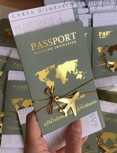 the passport is being held up by someone's hand with gold foil on it