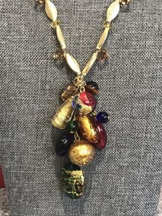 Beautiful Italian Murano beads are fashioned into a decorative statement cluster that is the centerpiece of this necklace.  The drop of beads measures 3 inches long by about 1 1/2 inches wide.  The necklace is 18 inches long.  There are smaller glass beads amongst the vibrant Murano beads.  There is a gold filled hook and gold filled findings. Vintage Gold Jewelry With Large Beads, Gold Metal Beaded Necklace With Large Beads, Gold Metal Beaded Necklaces With Large Beads, Gold Beaded Necklace With Large Metal Beads, Gold Metal Necklace With Large Beads, Gold Necklace With Large Metal Beads, Costume Jewelry Necklaces With Dangling Beads For Parties, Gold Czech Glass Bohemian Necklace, Vintage Czech Glass Necklaces For Party