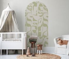 a baby's room with a white crib and green wallpaper