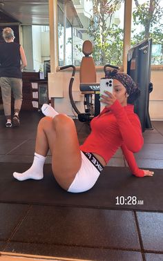 a woman laying on the ground taking a selfie in front of a computer monitor