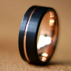 a black and gold wedding ring on a table