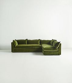 a large green couch sitting on top of a white floor