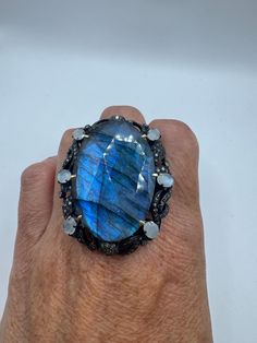 This ring is 20 grams total, consisting of 925 sterling silver, sandwiched in 18k gold around a brilliant 67.2 carat labradorite and set with 2.05 carats of diamonds and fiery rainbow moonstone  We are struggling to take photographs which do justice to the silverwork of this phenomenal one-of-a-kind ring.  This ring is part of the Nemesis Revival Collection. This is a substantial statement ring  We have in a size 9 this can be sized to your specification, please message us to discuss sizing your Mermaid Ring, 18k Gold Ring, Stylish Gifts, 2 Carat, Rainbow Moonstone, Silver Band, Statement Ring, Rings Statement, 925 Sterling Silver Ring