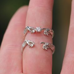 a person's hand is holding three rings with elephants on them, one in the middle