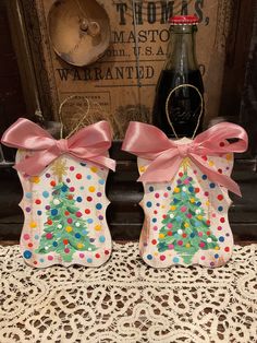 two ceramic christmas stockings with pink bows and polka dots on them, next to a bottle of booze