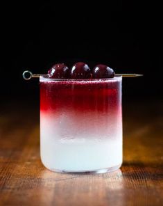 a small glass filled with liquid and cherries