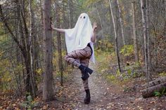 a woman dressed as a ghost in the woods