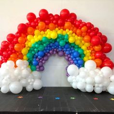 a rainbow made out of balloons and confetti