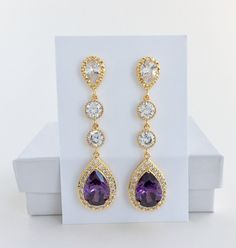 I've created these absolutely gorgeous super sparkly long purple amethyst crystal earrings in gold plated brass setting. Earrings feature a large teardrop with pear cut purple amethyst cubic zirconia center surrounded by tiny round zirconia crystals. Teardrop dangles from a bright cubic zirconia ear stud and two round cubic zirconia connectors. Total length of the earrings is 6 cms. For matching necklace click: For matching bracelet click: To browse my collection click : https://www.etsy.com/sho Luxury Purple, Purple Bridesmaid, Gold Bridal Necklace, Crystal Wedding Jewelry, Purple Bridesmaids, Gold Bridal Earrings, Amethyst Gold, Ear Stud, Matching Bracelet