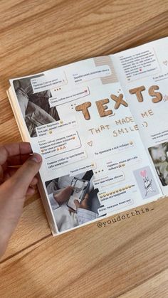 a person is holding an open book on a wooden table