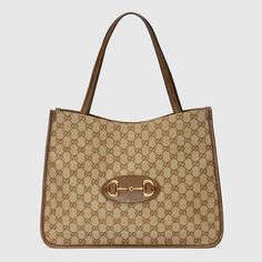 Designed with rounded edges and a soft shape, the tote bag is introduced to the Gucci Horsebit 1955 collection for Spring Summer 2020. Made from GG Supreme canvas with brown leather trim, the double-handled silhouette is finished with an organizational interior and magnetic snap closure. The collection unifies details first introduced on the original bag that inspired the line from over six decades ago with a modern spirit, highlighting the Horsebit. Part of GucciÆ’??s genetic code, the double r Gucci Gifts, Gucci Horsebit, Gucci Tote, Designer Totes, Gucci Shoulder Bag, Original Bags, Medium Tote, Designer Shoulder Bags, Tote Bag Leather