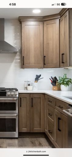 a kitchen with wooden cabinets and stainless steel stove top oven in the center, surrounded by wood flooring