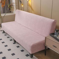 a pink couch sitting on top of a white floor next to a window with curtains