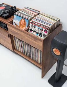 an entertainment center with record players, cds and records on the shelf next to it