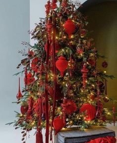 a christmas tree decorated with red ornaments and lights