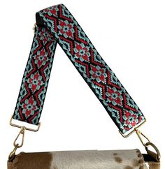 Description      Embroidered   Nylon Replacement Bag Strap  . This multipurpose red and teal e mbroidered  strap can be used on any travel bag, purse, crossbody or item of your choosing that has a snap on strap. This strap measures approx 2" wide and adjusts from 25" to 50" long, with brass plated snaps on each end.     *Bag not included*      CLEARANCE     This is a Closeout/Discontinued item. Sizes, colors and quantities are limited.  No refunds/No exchanges on Closeout/Discontinued items. Products are sold as is. Purse Crossbody, Red And Teal, Bag Straps, Travel Bag, Purse, Brass, Red, Travel, Color