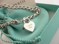 Offered for sale is a wonderful and rare Tiffany and Co. Sterling Silver "I Love You" Heart Padlock bracelet. The piece is made from substantial and bright Tiffany silver, and yet retains a very feminine feel to it. Attached to its very substantial Tiffany Silver Textured charm bracelet is a Heart padlock charm with "I Love You" written in beautiful script. The "I Love You" heart padlock charm opens and closes and thus can be used as a charm on a necklace or as part of another charm bracelet! Su Padlock Bracelet, Heart Padlocks, Tiffany And Co, Tiffany Heart, Heart Charm Bracelet, Tiffany & Co., A Heart, I Love You, Charm Bracelet