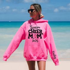 Introducing our exclusive Custom Senior Cheer Mom 2024 Hoodie with Cheerleader name on sleeve! Show off your pride for your cheerleading star with this one-of-a-kind hoodie. Made with the highest quality materials, this hoodie is both comfortable and stylish. The bold front design proudly showcases the phrase Senior Cheer Mom 2024, honoring your upcoming senior cheerleader. And that's not all - personalize the sleeve with your Cheerleader's name for an extra special touch. Whether you're cheerin Team Spirit Hoodie For Winter, Varsity Team Name Hoodie For Winter, Varsity Winter Hoodie With Team Name, School Spirit Long Sleeve Hoodie For Sports Season, School Spirit Hoodie For College, School Spirit Hooded Hoodie For College, College Hoodie With School Spirit, Long Sleeve College Hoodie For Sports Season, Team Name Fleece Hoodie