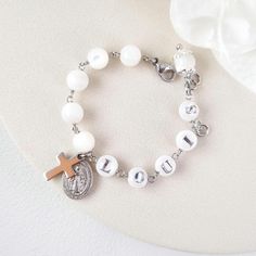 This stunning Baptism bracelet is a truly divine piece that combines elegance and spiritual significance. Crafted with natural mother of pearl beads, it features gold plated virgin Mary and cross charms that symbolize protection and faith. The bracelet is personalized with a handcrafted initial letter, adding a unique touch to this meaningful piece. Perfect for commemorating a special occasion or as a thoughtful gift, this bracelet is a beautiful reminder of faith and blessings. *MATCHING ROSARY Baptism Bracelet, Baby Girl Boy, Communion Gifts, Holy Communion, Initial Letter, Cross Charms, Birthday Present, Virgin Mary, Birthday Presents