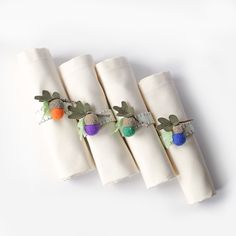 four white napkins with fruit and leaves on them