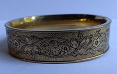 "This lovely antique gold fill black enamel engraved floral design bangle clamp bracelet is signed 120/10K GF P&H. Measures 7\" around the inside. The width is 5/8\". Weighs 25.8 grams. Has a safety chain. This bracelet is an oval shape. Very nice condition." Luxury Vintage Engraved Bangle, Clamp Bracelet, Laurel Burch Cats, Coral Bracelet, Laurel Burch, Safety Chain, Photo Bracelet, Cat Pin, White Enamel