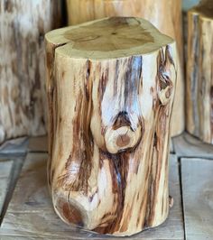 two wooden stools made out of tree stumps on the floor, one with a face carved into it