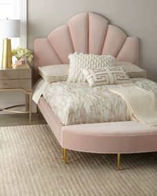 a pink bed sitting in a bedroom next to a dresser and lamp on top of a rug