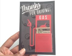 a hand holding up a card with a gas pump on it that says thanks for driving