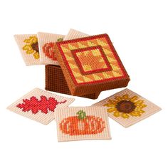 cross stitch coasters with autumn designs on the front and back, set of four