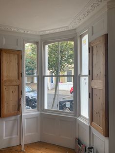 an empty room with wooden doors and windows