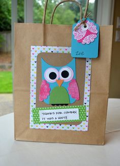 a brown paper bag with an owl on it and a tag hanging from the handle