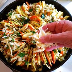 a hand is picking up some food from a skillet