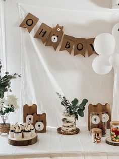 a table topped with cakes and desserts covered in brown paper letters that spell out oh boy