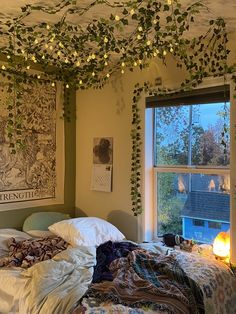 an unmade bed in a bedroom with ivy growing on the ceiling and lights above it