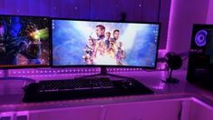 two computer monitors sitting next to each other on top of a white desk in front of a purple light